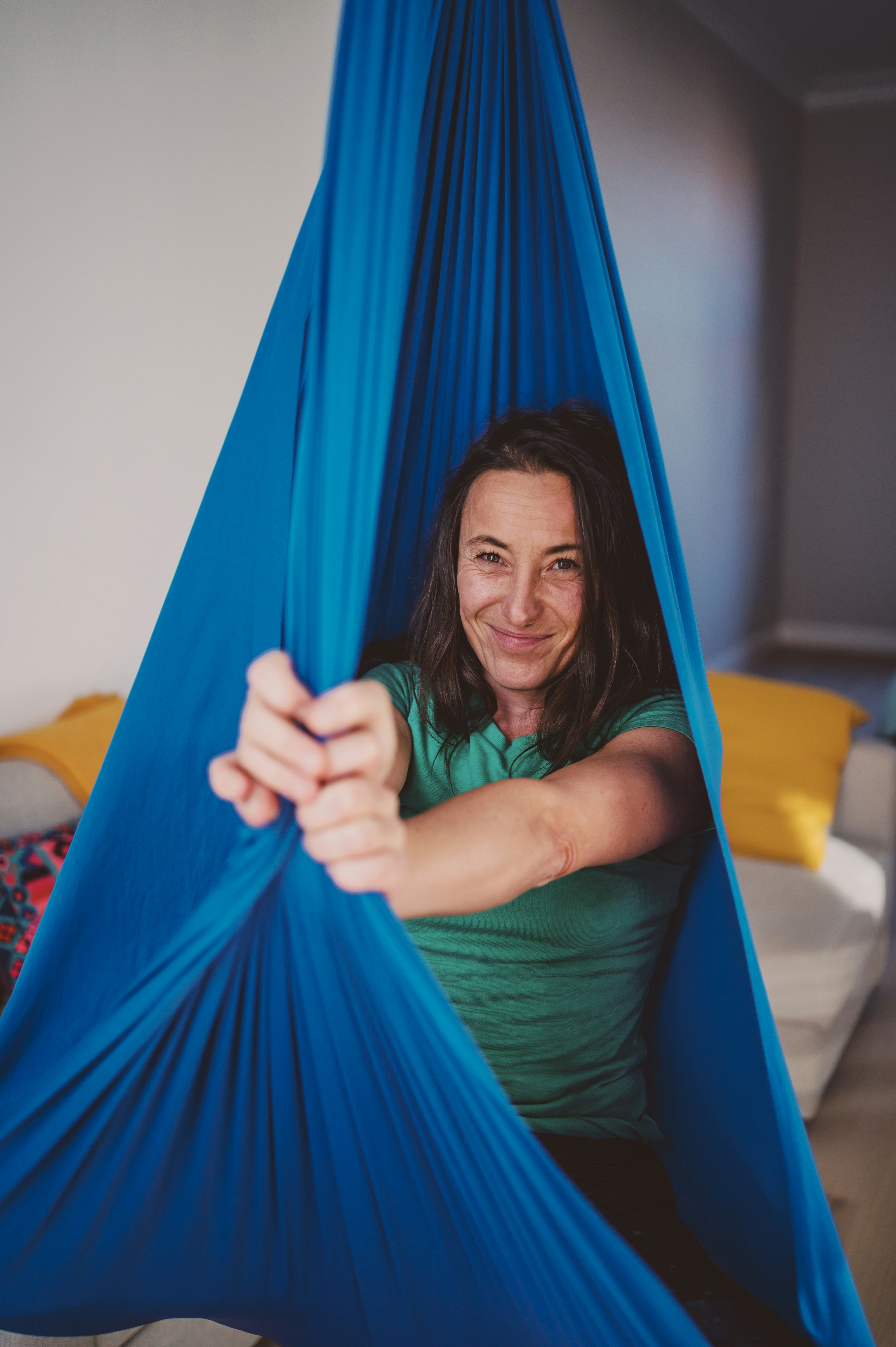 woman in green tank top lying on blue hammock